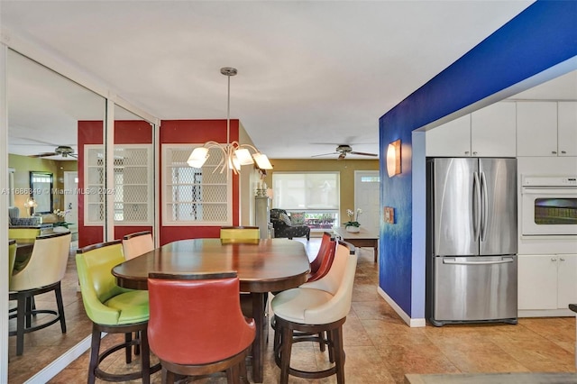 dining room featuring ceiling fan with notable chandelier