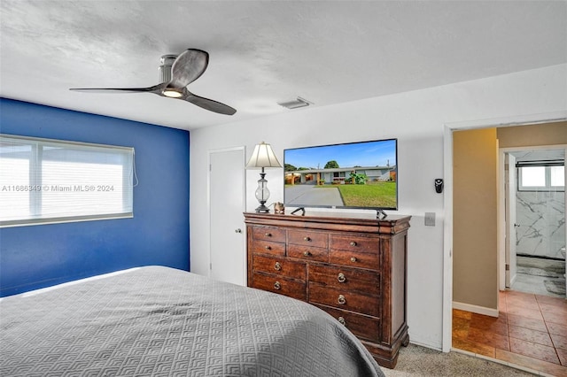 bedroom with carpet flooring, ceiling fan, and ensuite bathroom