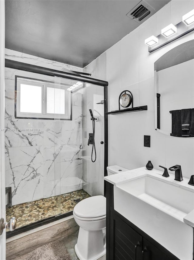 bathroom featuring vanity, hardwood / wood-style flooring, toilet, and an enclosed shower