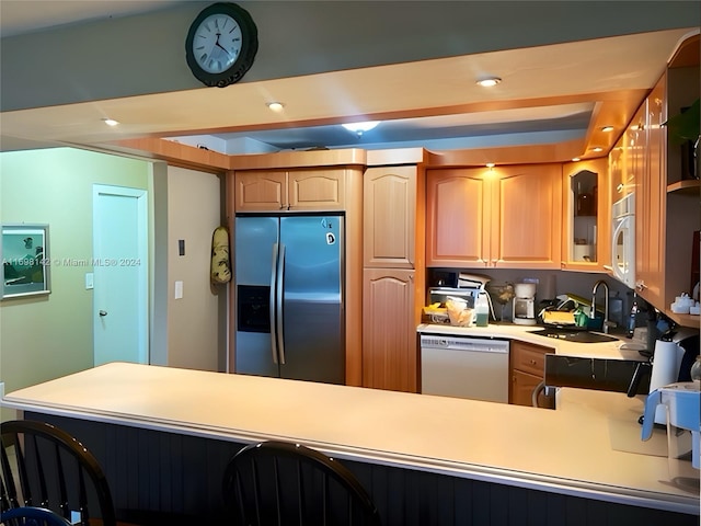 kitchen with kitchen peninsula, white appliances, and sink