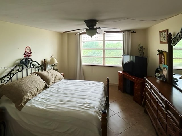 bedroom with tile patterned floors, multiple windows, and ceiling fan