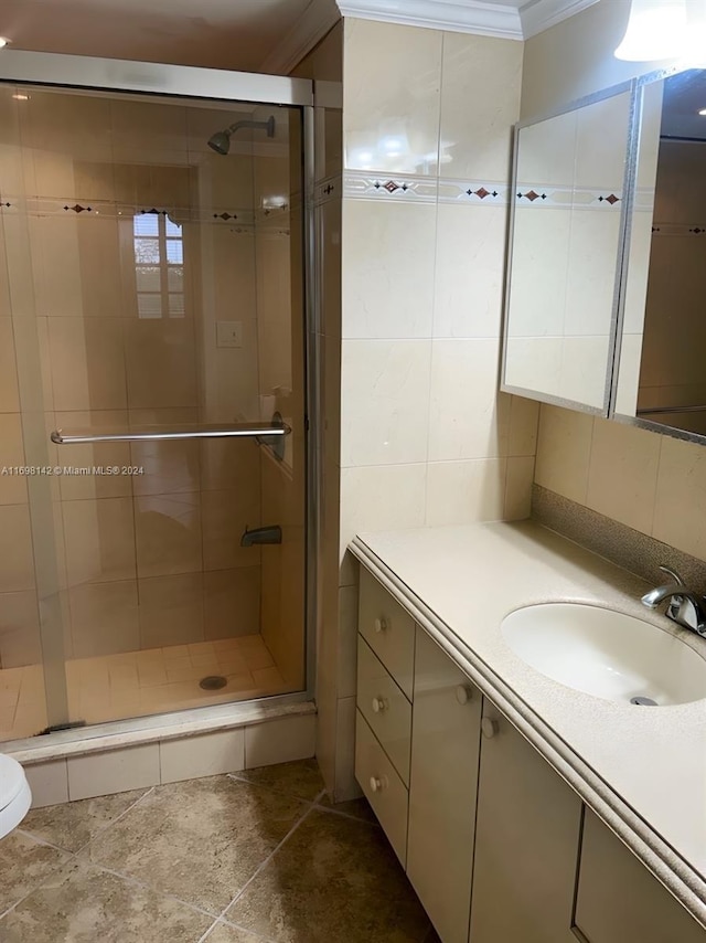 bathroom with decorative backsplash, a shower with shower door, ornamental molding, and vanity