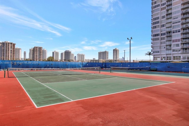 view of tennis court featuring basketball hoop