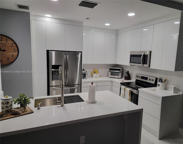 kitchen featuring modern cabinets, visible vents, appliances with stainless steel finishes, and white cabinets