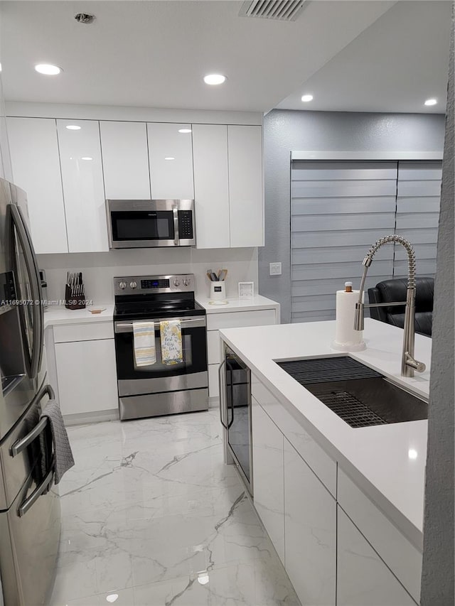 kitchen with sink, white cabinets, and stainless steel appliances