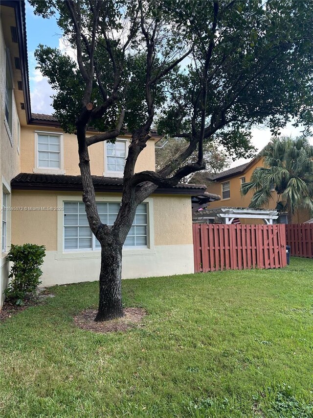 view of side of property with a pergola and a yard