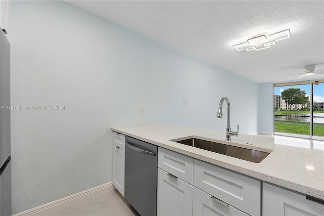 kitchen featuring white cabinets, light stone counters, a textured ceiling, sink, and dishwasher