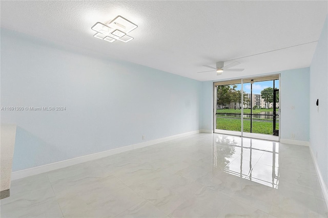 empty room featuring ceiling fan and a textured ceiling