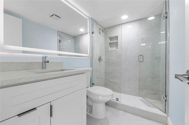 bathroom with vanity, toilet, and a shower with door