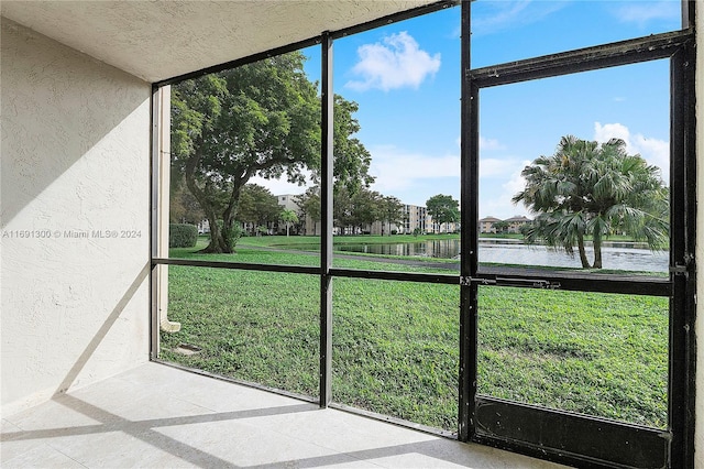 unfurnished sunroom with a water view