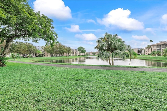 surrounding community featuring a water view and a lawn