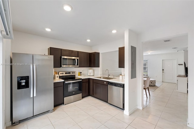 kitchen featuring light tile patterned flooring, appliances with stainless steel finishes, dark brown cabinetry, and sink