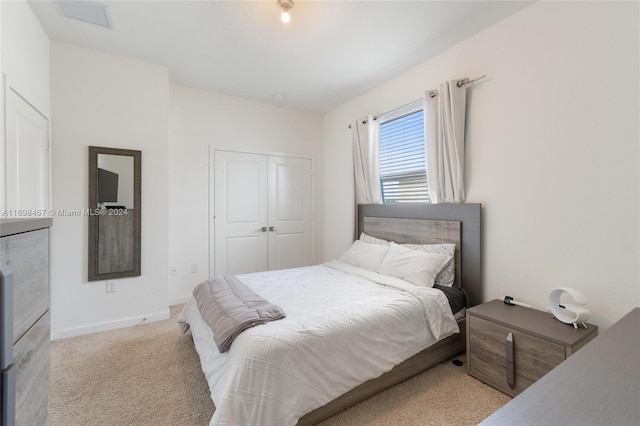 bedroom featuring light carpet and a closet