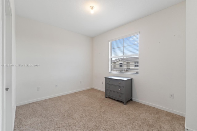 unfurnished room with light carpet