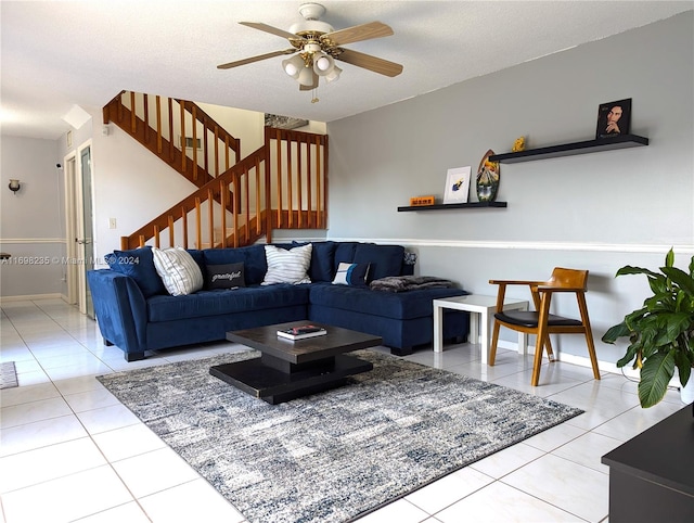 living room with ceiling fan, light tile patterned floors, and a textured ceiling