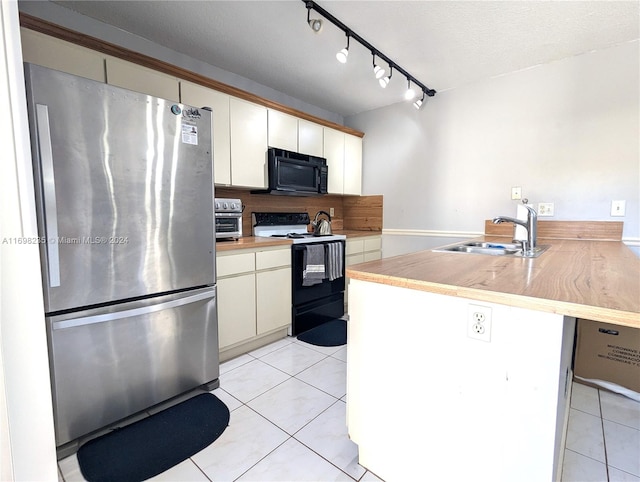 kitchen featuring a textured ceiling, sink, black appliances, light tile patterned floors, and white cabinetry