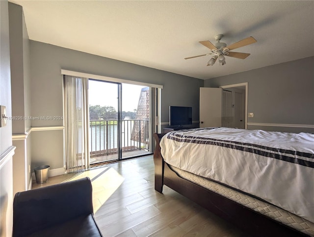 bedroom featuring a textured ceiling, access to outside, light hardwood / wood-style flooring, and ceiling fan