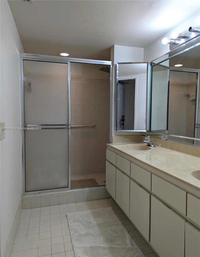 bathroom featuring tile patterned flooring, vanity, and a shower with shower door