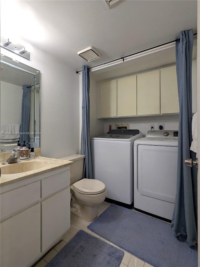 bathroom featuring washer and dryer, vanity, tile patterned flooring, and toilet