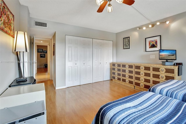 bedroom with a textured ceiling, hardwood / wood-style flooring, a closet, and ceiling fan