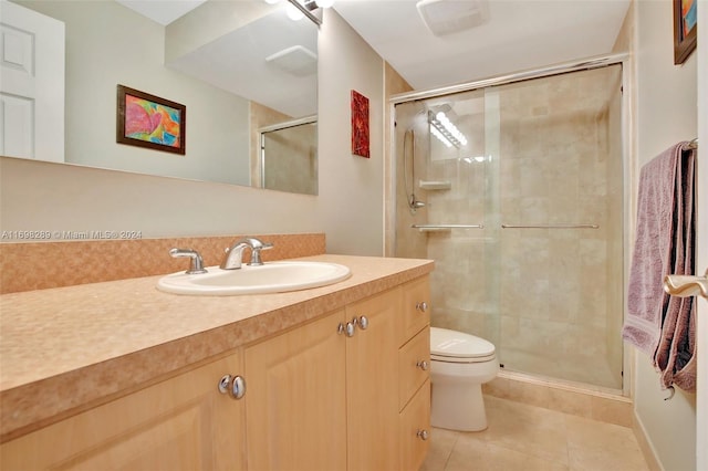 bathroom featuring toilet, vanity, tile patterned floors, and walk in shower