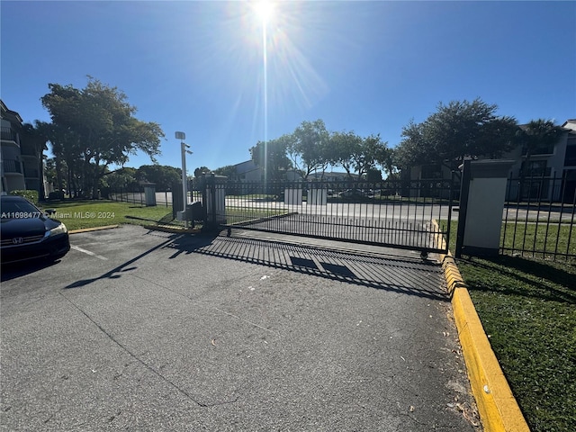 view of gate with a lawn