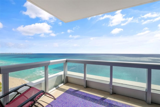 balcony featuring a water view and a beach view