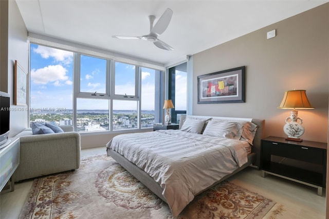 bedroom featuring expansive windows, light hardwood / wood-style flooring, and ceiling fan