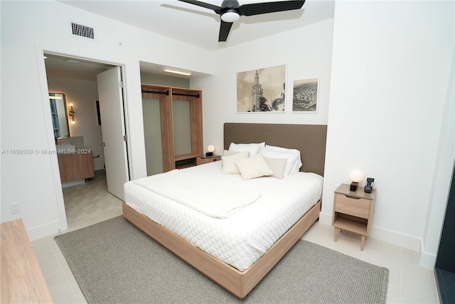 bedroom with ceiling fan, a barn door, and a closet