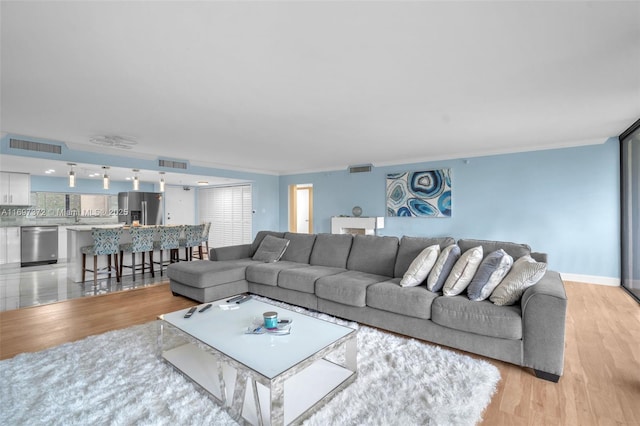 living room with crown molding and light hardwood / wood-style flooring