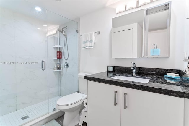 bathroom featuring toilet, vanity, and walk in shower