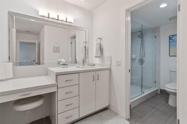 bathroom with tile patterned flooring, toilet, vanity, and walk in shower