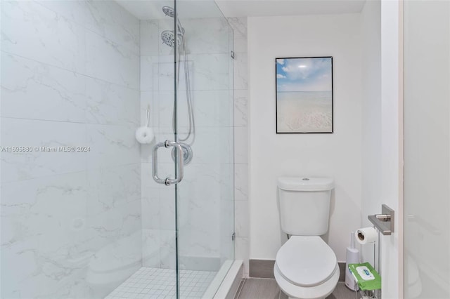 bathroom featuring toilet and a shower with shower door