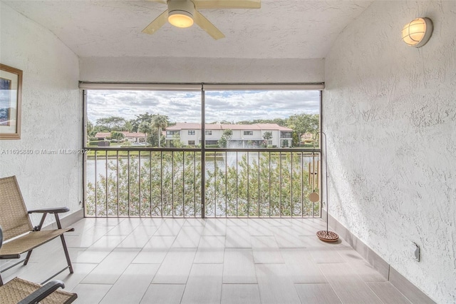 unfurnished sunroom with ceiling fan and plenty of natural light