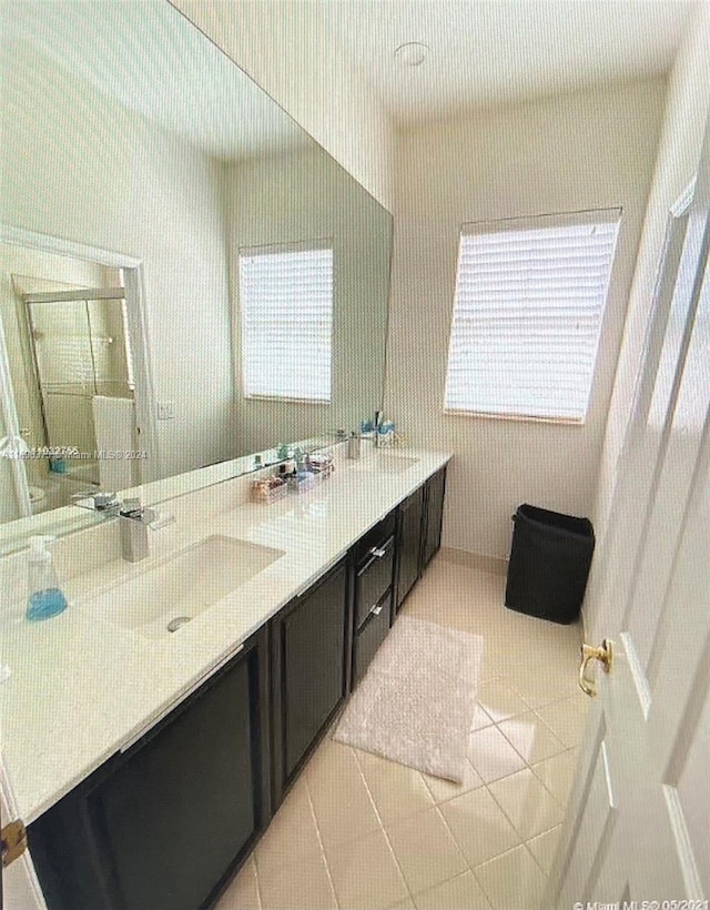 bathroom featuring tile patterned flooring, vanity, and a healthy amount of sunlight