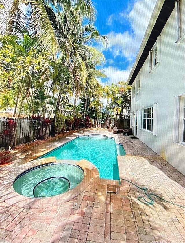 view of pool with a patio area and an in ground hot tub