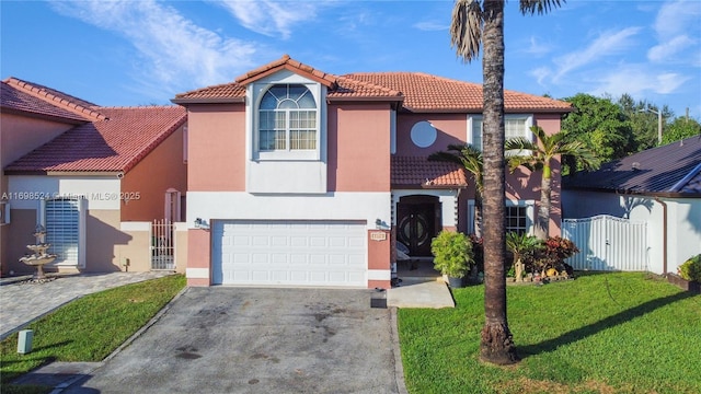 mediterranean / spanish-style house featuring a garage and a front lawn