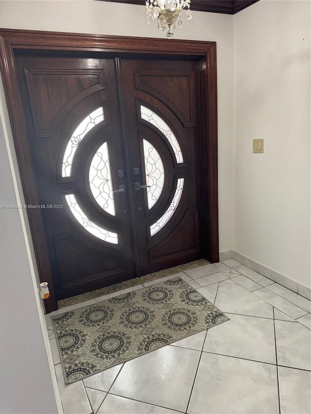 tiled entrance foyer with a chandelier