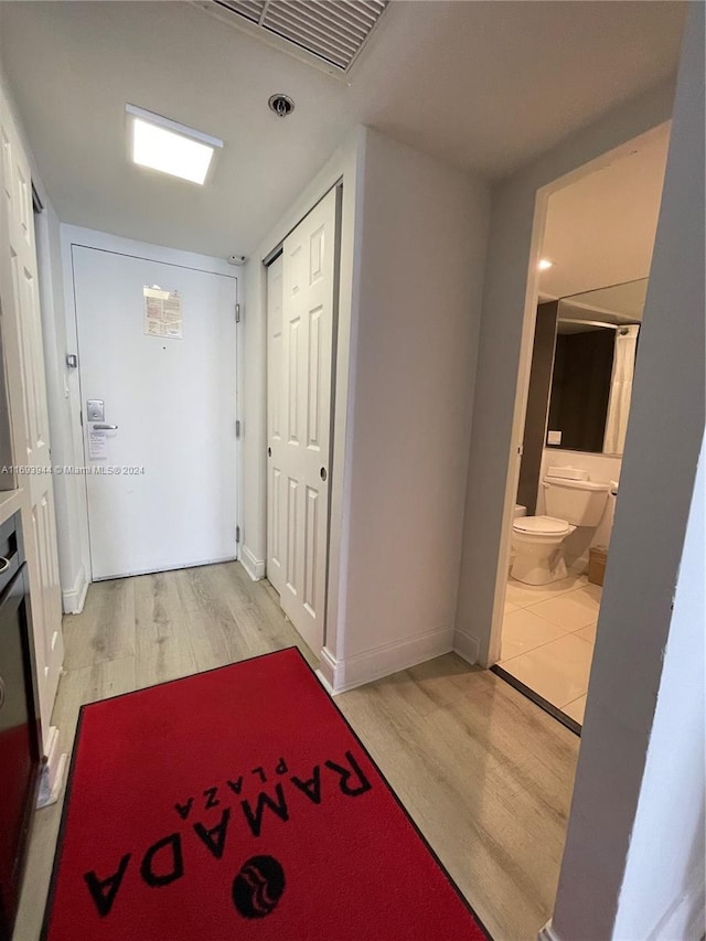 hallway with light hardwood / wood-style floors