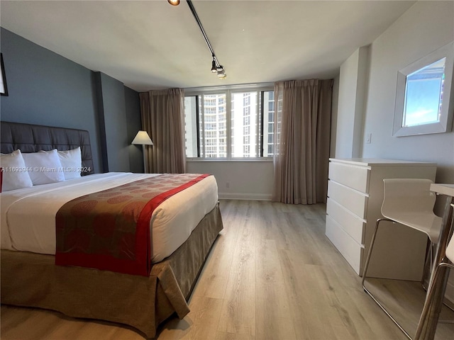 bedroom featuring light hardwood / wood-style flooring and track lighting