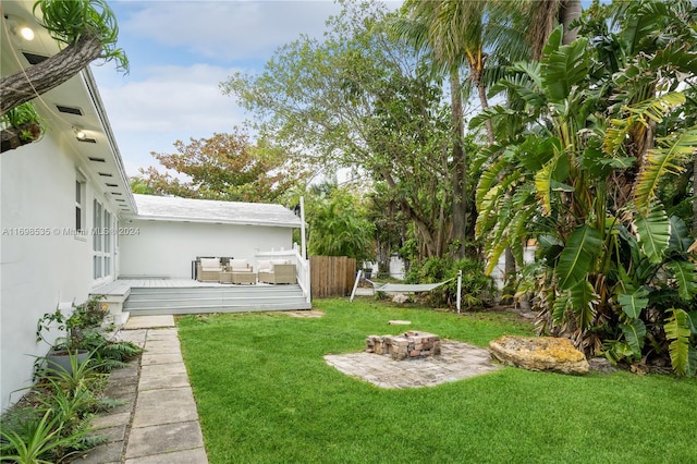 view of yard with a patio, a deck, and an outdoor fire pit