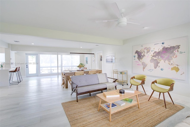 living room featuring ceiling fan and light wood-type flooring