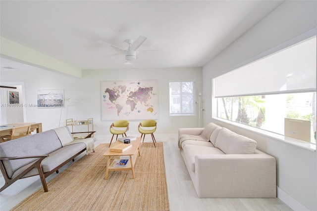 living room featuring ceiling fan and light hardwood / wood-style flooring