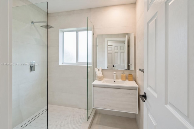 bathroom with tiled shower and vanity