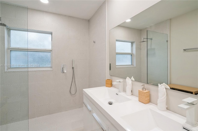 bathroom featuring a tile shower and vanity