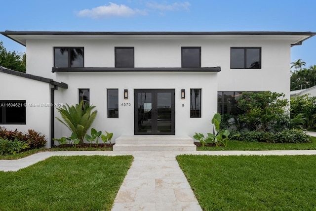 modern home with french doors and a front lawn