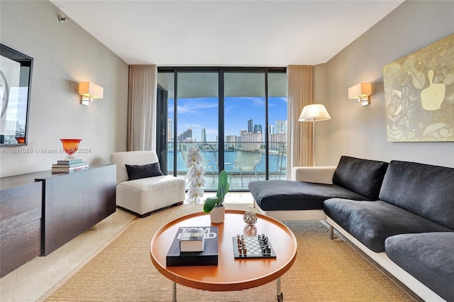 living room featuring a water view, expansive windows, and light tile patterned flooring