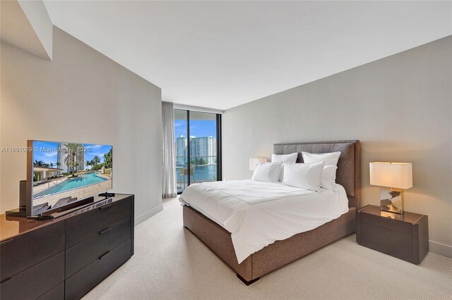 carpeted bedroom with access to outside and a wall of windows