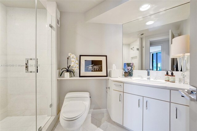 bathroom featuring vanity, an enclosed shower, and toilet