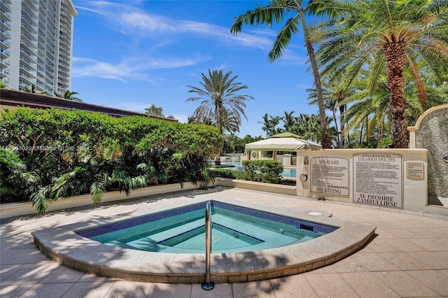 view of swimming pool with a hot tub